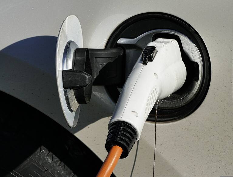 Ein Elektrofahrzeug wird mit einem Ladestecker aufgeladen.